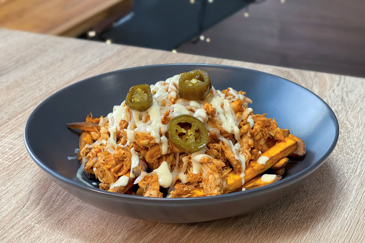 Loaded Sweet Potato Fries with BBQ, pulled chicken, cheese, honey mustard sauce and sliced jalapeños