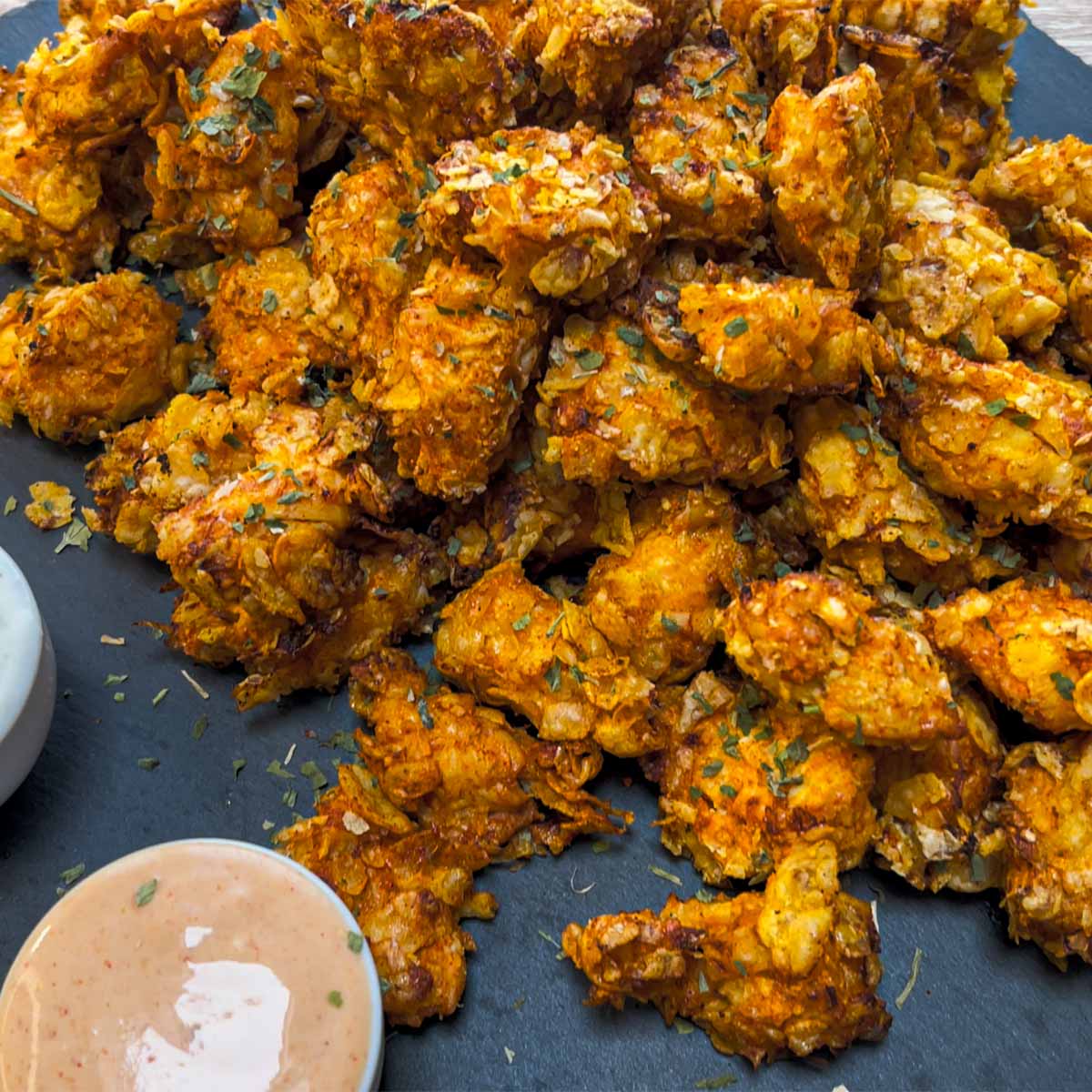 Close-up photo of Air Fryer Popcorn Chicken with Dipping Sauces served on a stone plate